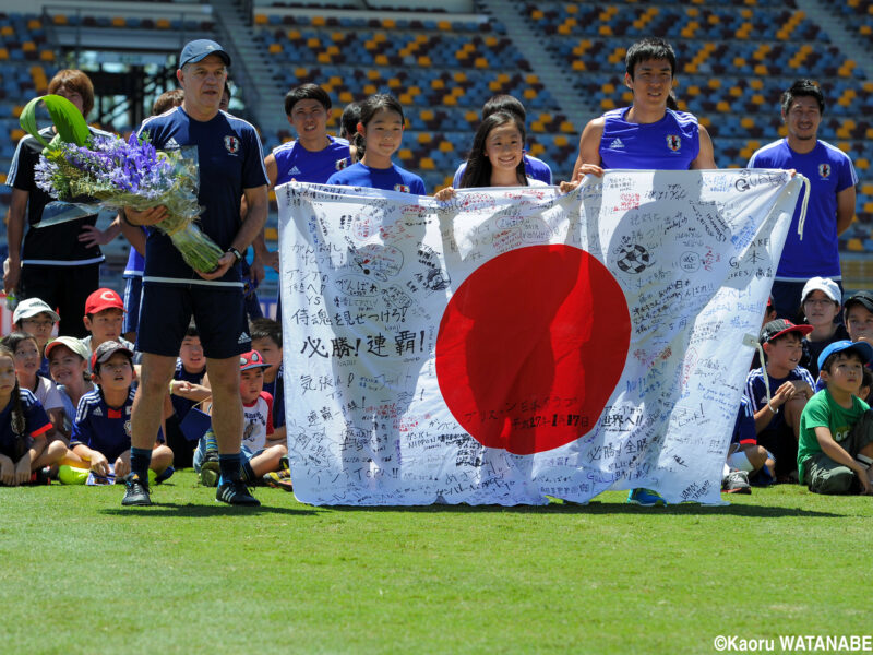 サッカー日本代表が参加するアジアカップオーストラリア大会にて現地の日本人学校の生徒たちと交流し、チームを代表して激励メッセージが入った日の丸の旗を受け取るキャプテン・長谷部誠とアギーレ監督たち