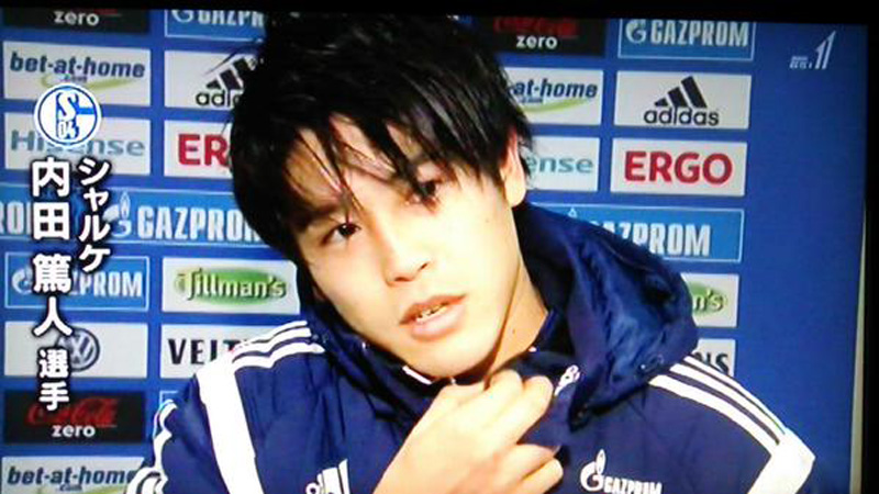 ドイツ・ブンデスリーガのシャルケの試合後のインタビューに答える内田篤人と、彼にちょっかいをかけるために後ろから忍び寄るチームマスコットのエルウィン