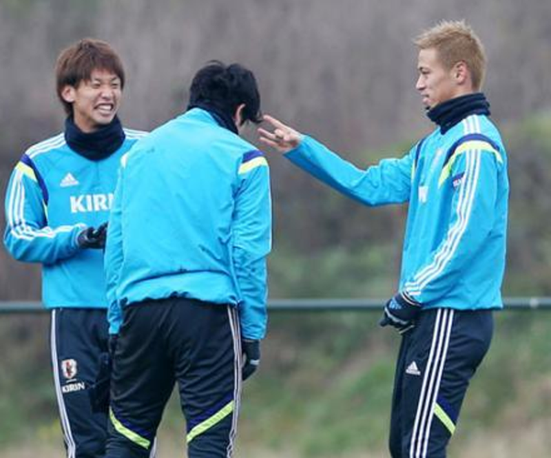 サッカー日本代表チームでの練習中にふざけあいながら内田篤人にデコピンをする本田圭佑と、その様子を大笑いで眺める大迫勇也
