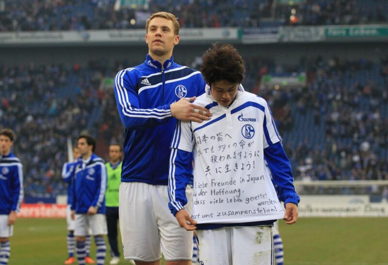 2011年3月11日に発生した東日本大震災の被災地と被災者へのエールを記したメッセージシャツを着た、翌3月12日開催のドイツでの試合後の内田篤人と、テレビカメラの前にエスコートするマヌエル・ノイアー