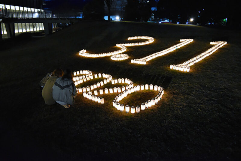 東日本大震災発生から9年経過した2020年3月11日、福島県いわき市の平中央公園にてカップに復興の願いなどが書かれたロウソクを見る住民たち
