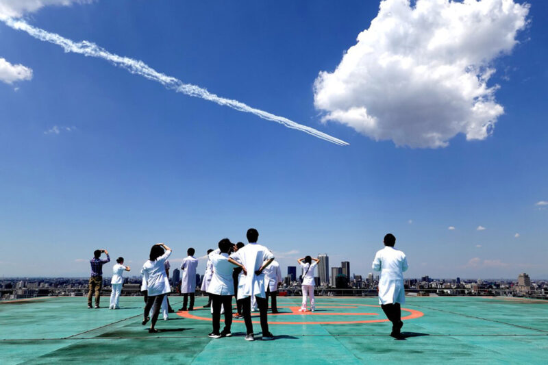 新型コロナウイルス感染症に対応中の医療従事者と多くの国民に感謝と激励を伝えるため、東京の都心上空で編隊飛行をおこなった航空自衛隊のブルーインパルスを見上げる医療関係者