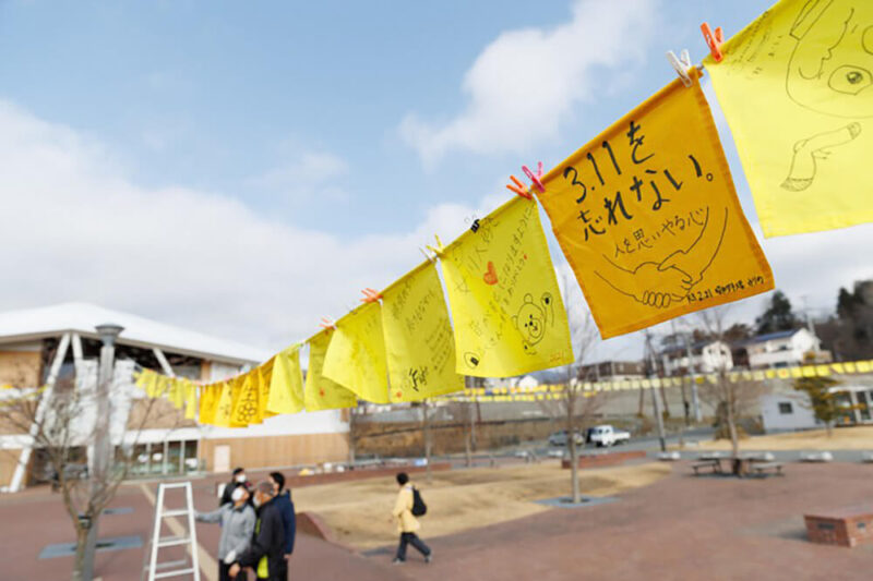 2022年3月11日午前9時前、宮城県女川町のJR女川駅前に掲げられた、震災で亡くなった人たちへの思いがつづられた黄色いハンカチ